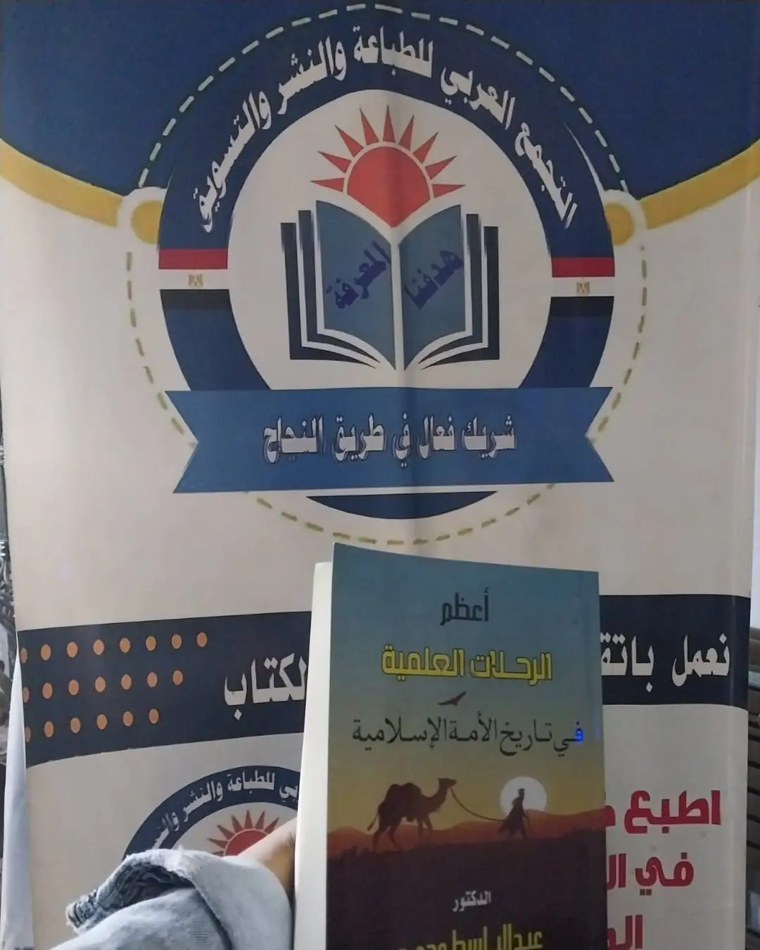 «أعظم الرحلات العلمية» أمام شعار دار التجمع العربي للطباعة والنشر والتسويق.